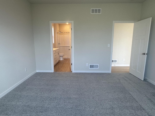 unfurnished bedroom featuring connected bathroom and light colored carpet