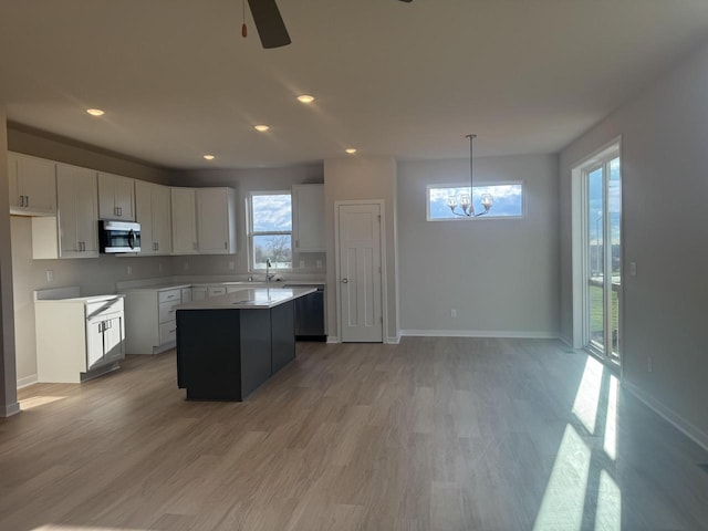 kitchen featuring white cabinets, a kitchen island, pendant lighting, and light hardwood / wood-style floors