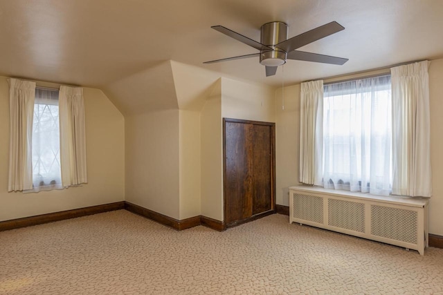 bonus room featuring ceiling fan, radiator heating unit, and vaulted ceiling