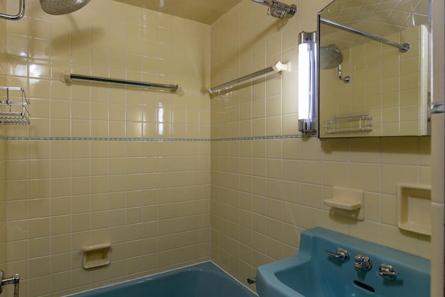 bathroom with tiled shower / bath combo and tile walls