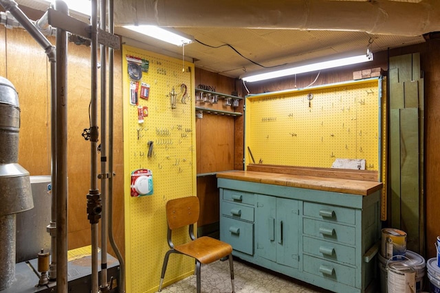 basement featuring a workshop area and wooden walls