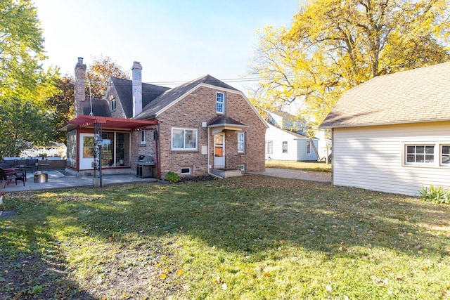 rear view of house with a lawn and a patio