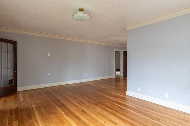 empty room featuring hardwood / wood-style floors, a textured ceiling, and crown molding