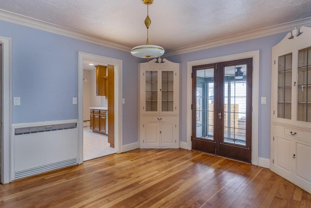 unfurnished dining area with french doors, light hardwood / wood-style floors, and ornamental molding