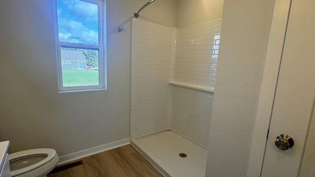 bathroom with a shower, hardwood / wood-style floors, and toilet