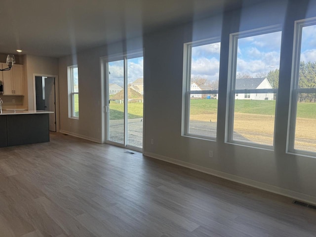 unfurnished living room featuring plenty of natural light and hardwood / wood-style flooring