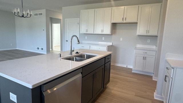 kitchen featuring white cabinets, light hardwood / wood-style floors, stainless steel dishwasher, and sink