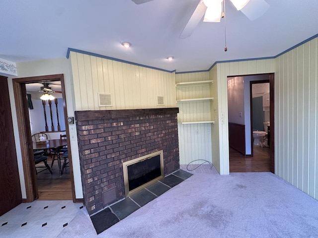 bedroom with hardwood / wood-style floors, wood walls, crown molding, and a brick fireplace