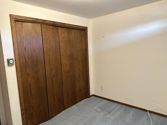 unfurnished bedroom with light carpet and a closet