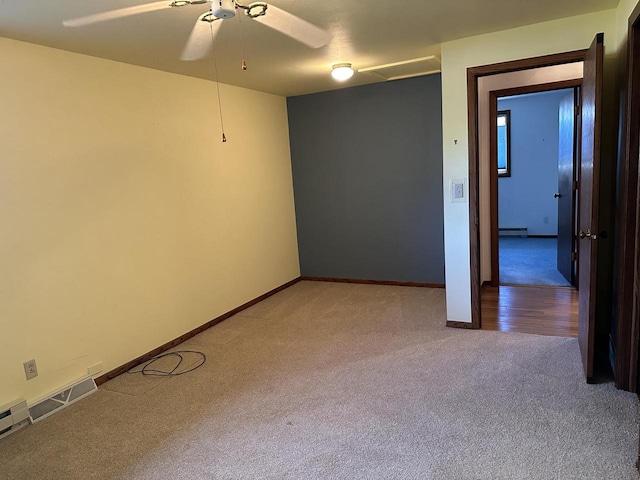 empty room with carpet flooring, ceiling fan, and a baseboard radiator