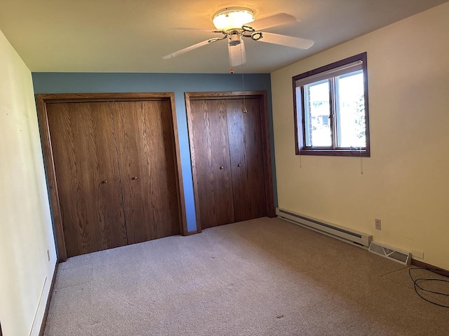 unfurnished bedroom with ceiling fan, light carpet, two closets, and a baseboard heating unit