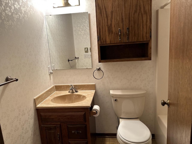 bathroom with tile patterned flooring, vanity, toilet, and a bathtub