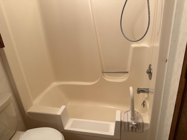 bathroom featuring a tub to relax in and toilet