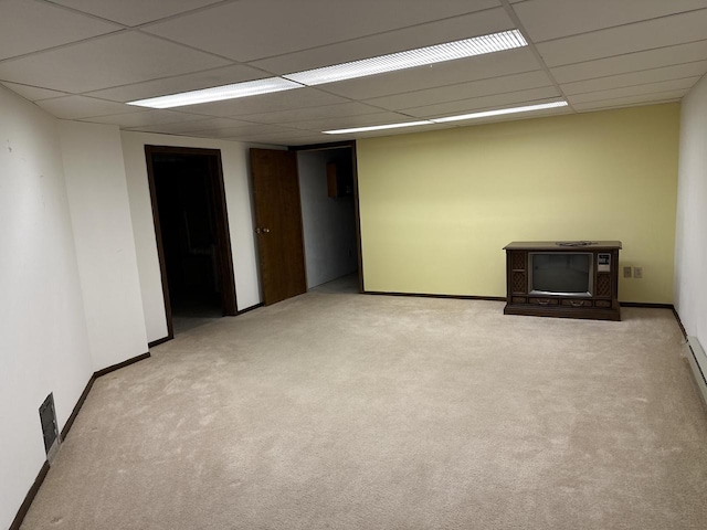 empty room with a drop ceiling and light carpet