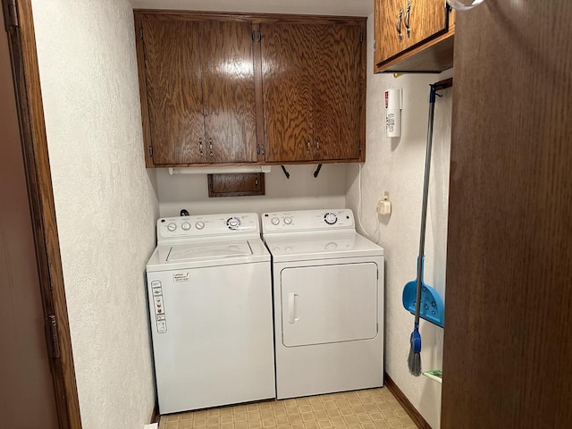 laundry room with cabinets and washer and clothes dryer