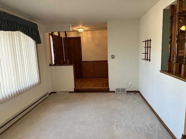 unfurnished room featuring carpet flooring and a baseboard heating unit