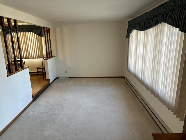 carpeted spare room featuring a baseboard radiator