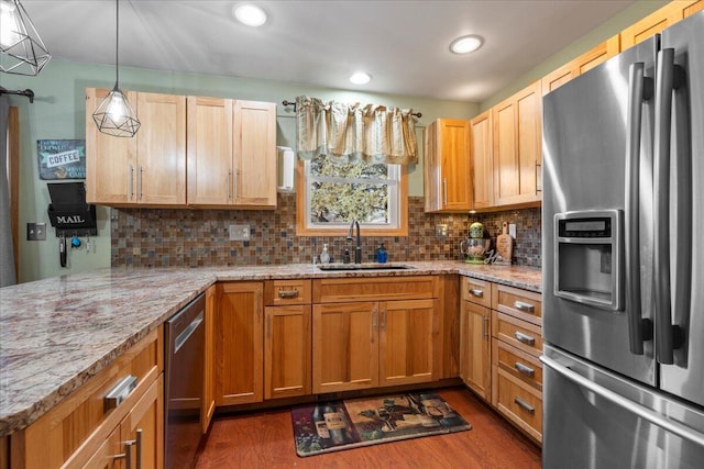 kitchen featuring pendant lighting, sink, dark hardwood / wood-style floors, light stone countertops, and appliances with stainless steel finishes