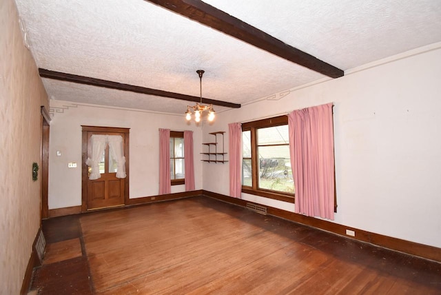 spare room with beamed ceiling, a textured ceiling, hardwood / wood-style flooring, and an inviting chandelier