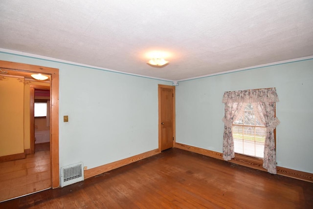 spare room featuring a textured ceiling and dark wood-type flooring