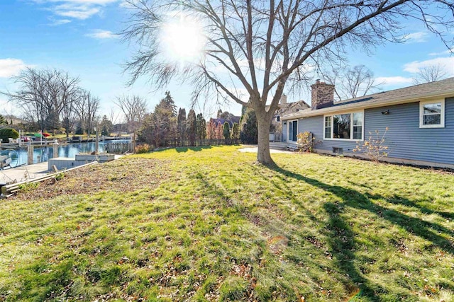 view of yard featuring a boat dock and a water view