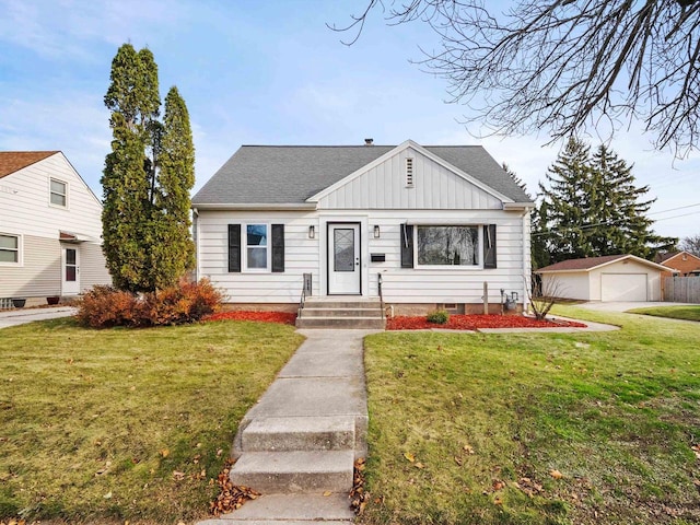 view of front facade featuring an outbuilding, a front lawn, and a garage