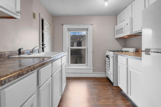 kitchen featuring white cabinets, white appliances, dark hardwood / wood-style floors, and sink