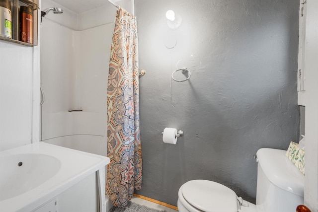 bathroom featuring a shower with curtain, toilet, and sink