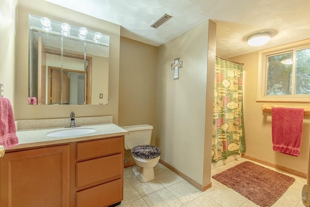 bathroom with tile patterned flooring, vanity, and toilet