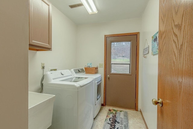 clothes washing area featuring washer and dryer, sink, and cabinets