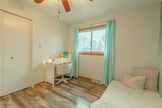 bedroom featuring ceiling fan, a closet, and hardwood / wood-style floors