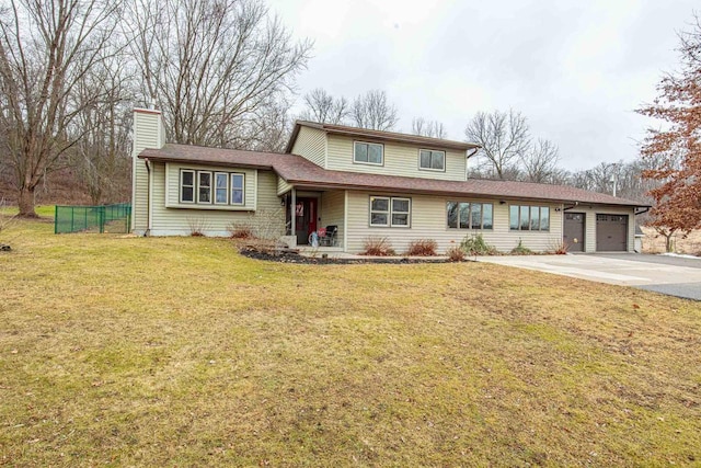 tri-level home featuring a garage and a front lawn