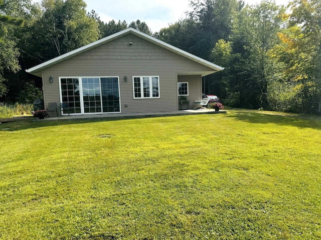 rear view of house featuring a yard