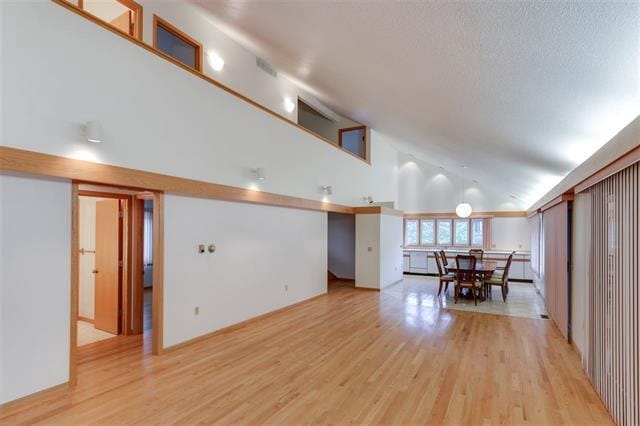 interior space featuring light hardwood / wood-style floors and high vaulted ceiling