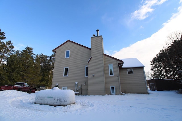 view of snow covered back of property