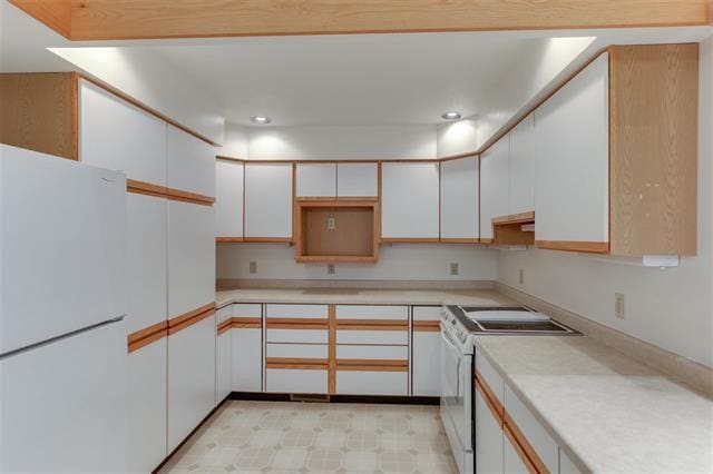 kitchen featuring white cabinets and white appliances