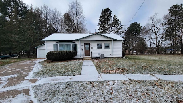 view of front of house with a front lawn, cooling unit, and a garage