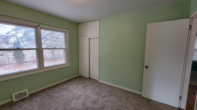 unfurnished bedroom featuring light carpet and a closet