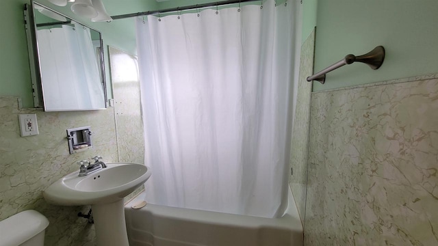 bathroom featuring toilet and shower / tub combo with curtain