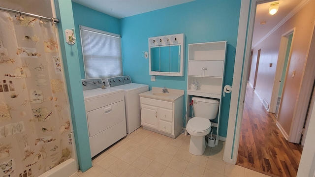 bathroom featuring independent washer and dryer, wood-type flooring, toilet, vanity, and ornamental molding