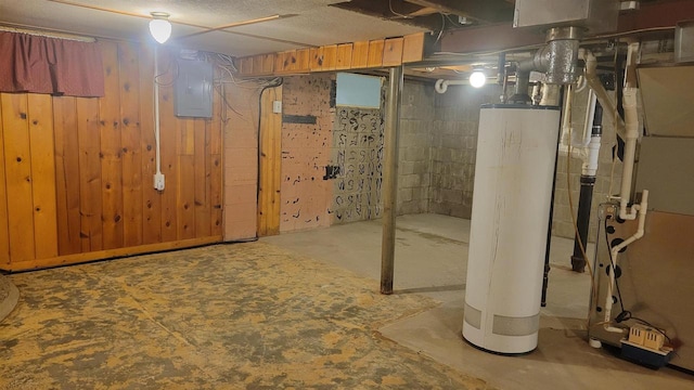 basement with wood walls, gas water heater, and electric panel