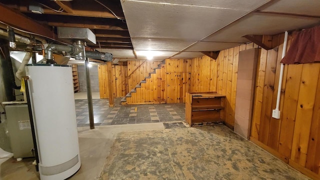 basement with wood walls and water heater