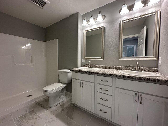 bathroom with a shower, vanity, and toilet