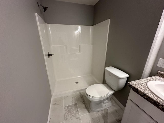 bathroom featuring toilet, a shower, and vanity