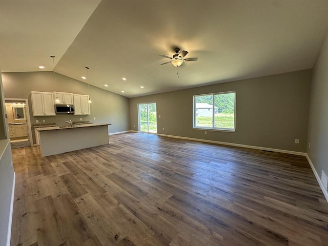 unfurnished living room featuring dark hardwood / wood-style flooring, ceiling fan, and lofted ceiling