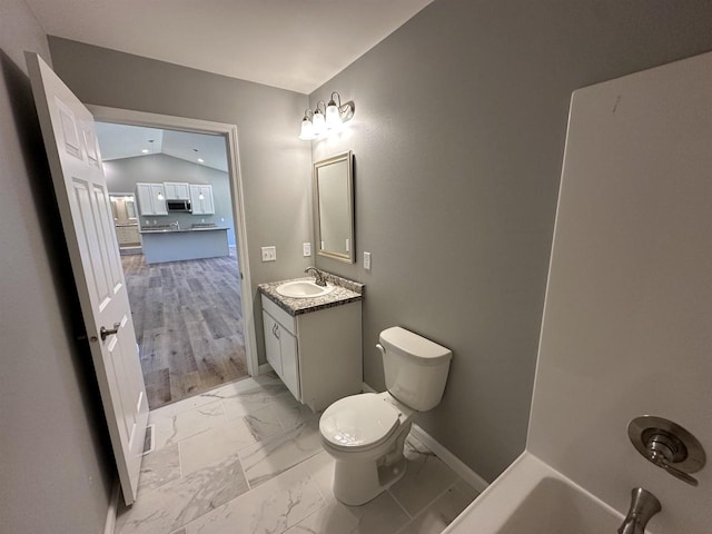 bathroom featuring vanity, hardwood / wood-style flooring, toilet, and lofted ceiling