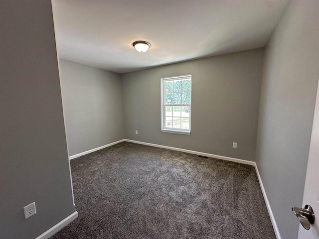 empty room featuring dark carpet