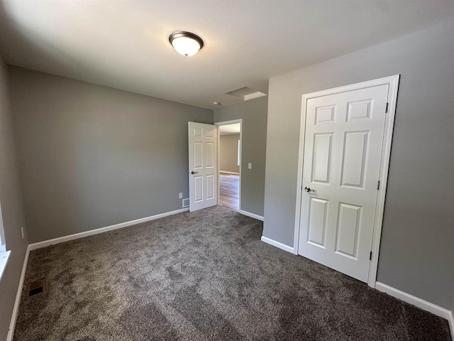 interior space with a closet and dark colored carpet