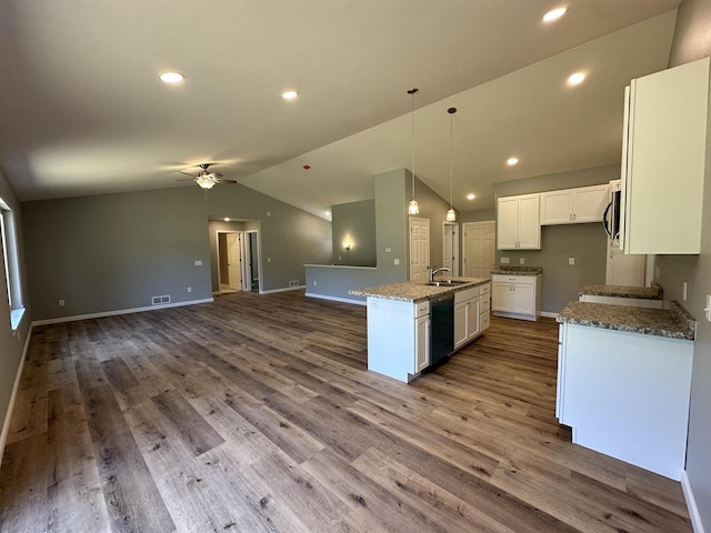 kitchen featuring vaulted ceiling, a kitchen island with sink, wood-type flooring, dishwasher, and white cabinetry