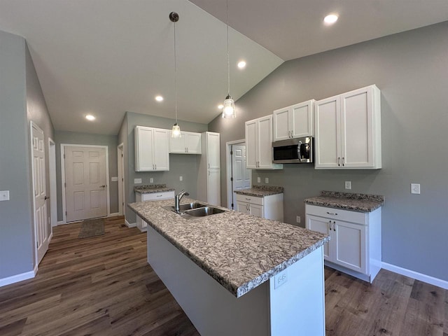 kitchen featuring sink, white cabinets, dark hardwood / wood-style floors, lofted ceiling, and an island with sink